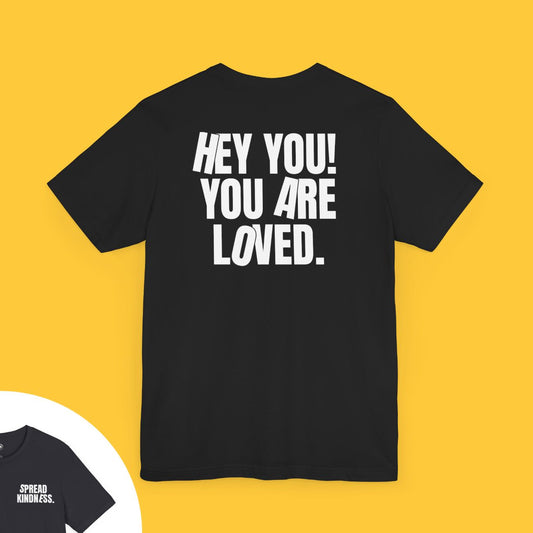 T-shirt with bold text on the back saying "HEY YOU! YOU ARE LOVED." and "SPREAD KINDNESS." on the front left chest.