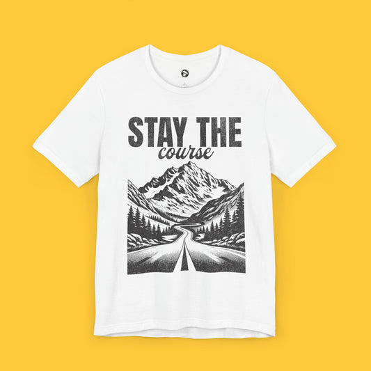 T-shirt featuring a landscape silhouette of a road through a forest leading to mountains with the quote "Stay the Course."