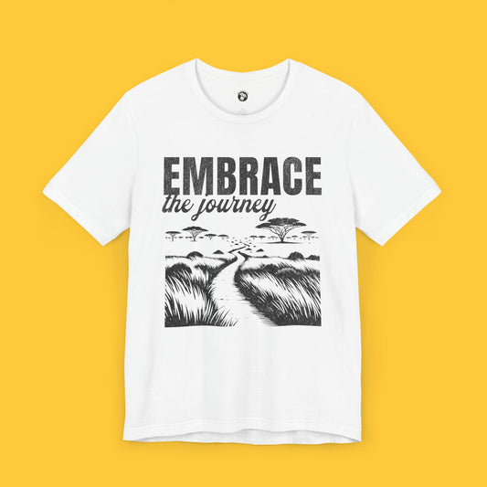 T-shirt featuring a landscape silhouette of a safari with a road and the quote "Embrace the Journey."