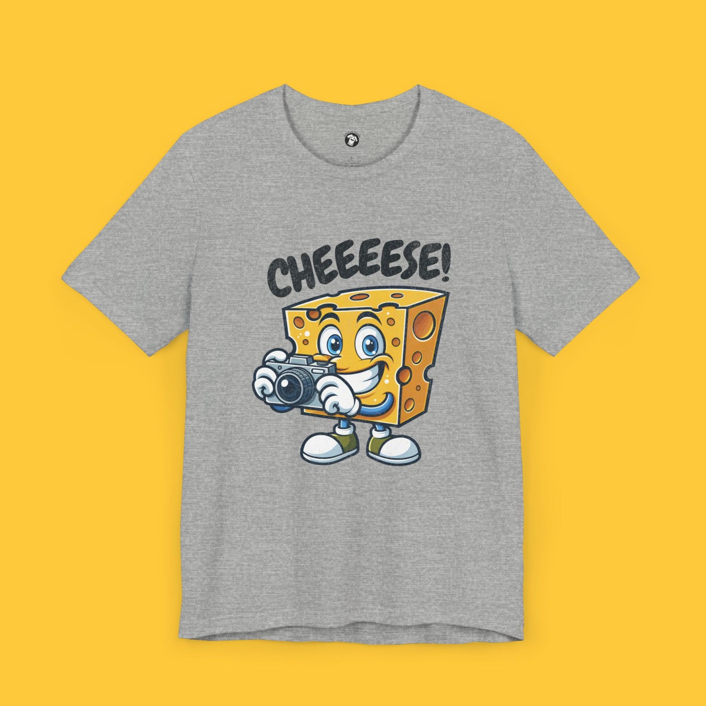 T-shirt featuring a cheese character holding a camera with the quote "Cheeeese!" in a playful font.