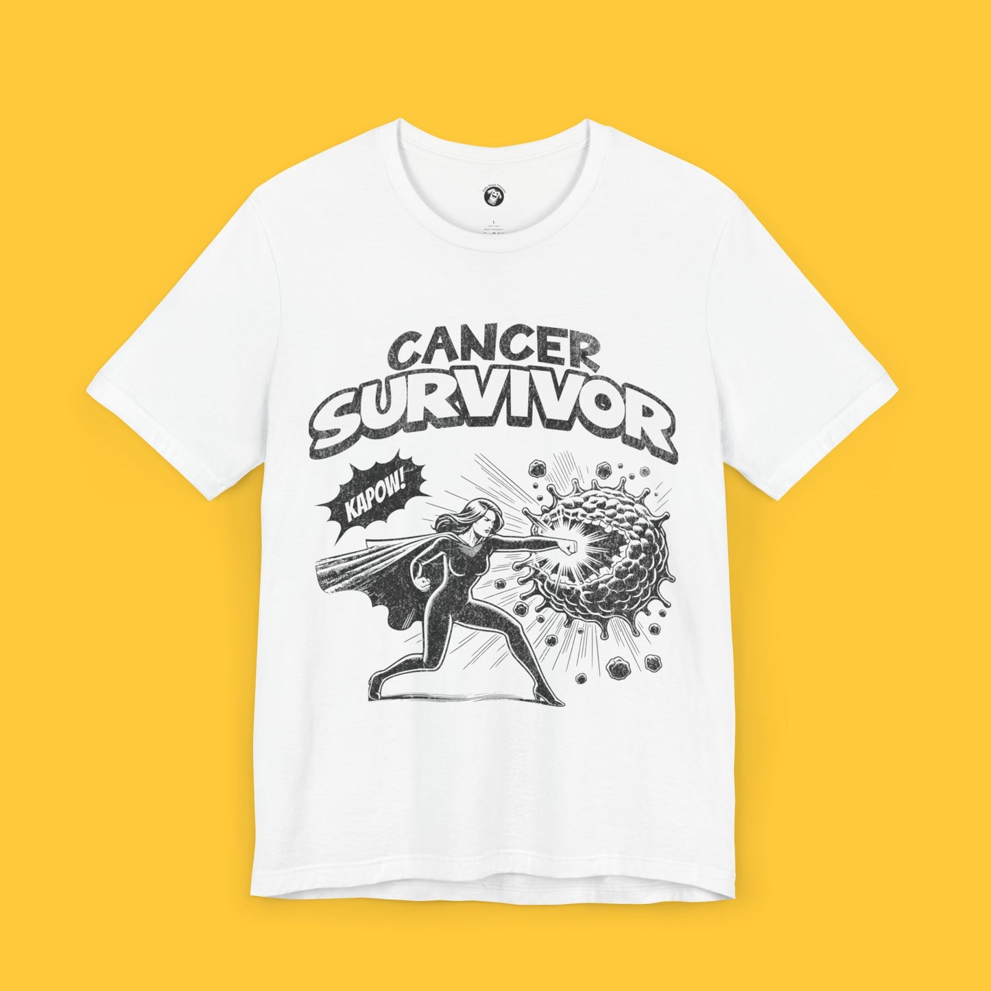 T-shirt featuring a superhero graphic with the text "Cancer Survivor" and a superhero figure punching cancer cells with a "KAPOW!" sound effect.